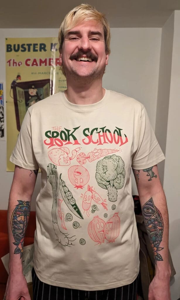 tshirt spook school avec plein de légumes dessinés dessus, porté par une personne très souriante